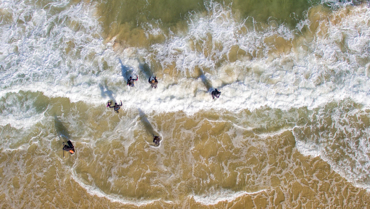 Freedivers going through the surf