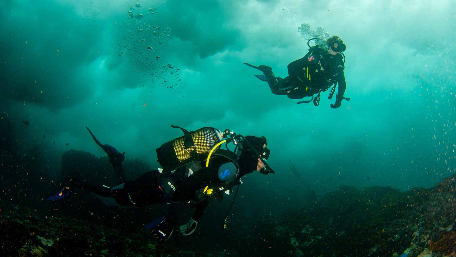 Divers in surgy water with perfect buoyancy