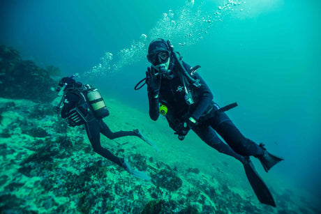 Scuba divers gliding over the reef with great buoyancy controll