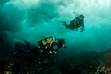 Divers in surgy water with perfect buoyancy