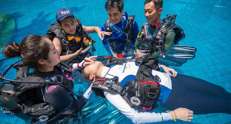 Divers learning in water rescue techniques on the PADI Rescue course