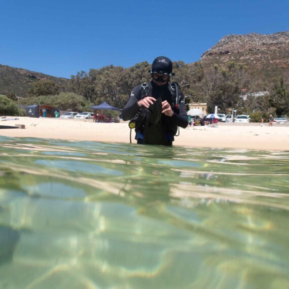 Shore diver cleaning his mask at Long Beach in Simonstown